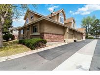 Townhouse exterior featuring a well-maintained lawn and a brick facade at 2136 S Scranton Way, Aurora, CO 80014