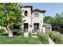Stunning home featuring a stucco and stone exterior with professional landscaping and a charming front porch at 3255 S Birch St, Denver, CO 80222