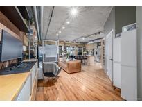 Bright, open living room features hardwood floors and modern industrial ceiling at 1499 Blake St # 4F, Denver, CO 80202