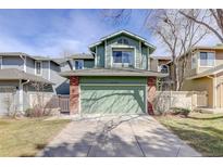 Inviting green exterior showcasing a two-story home with an attached two-car garage and brick accents at 8254 S Gaylord Cir, Centennial, CO 80122