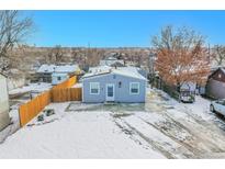 Charming single-story home featuring a fenced yard and a large driveway on a snow-covered lot at 3190 W Hawthorne Pl, Denver, CO 80221