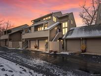Exterior view of multi-level townhome showcasing attached garages, neutral siding, and multiple windows at 6700 W 11Th Ave # 103, Lakewood, CO 80214
