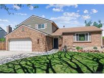 Charming brick home featuring an attached garage, landscaped front yard, and inviting entrance at 7724 S Lafayette Ct, Centennial, CO 80122