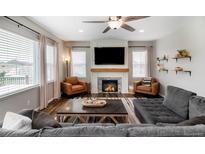 Inviting living room features a cozy fireplace, modern ceiling fan, and stylish furnishings at 2028 Trail Stone Ct, Castle Rock, CO 80108