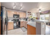 Bright kitchen featuring stainless steel appliances, tile floors, and ample countertop space at 8707 E Florida Ave # 410, Denver, CO 80247