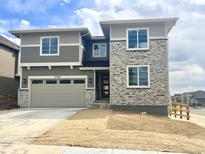 Two-story home features stone facade, gray siding, attached two-car garage and unfinished front yard at 24708 E 40Th Ave, Aurora, CO 80019