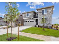 Beautiful two-story home with gray siding, stone accents, well-manicured lawn, and a two car garage at 24708 E 40Th Ave, Aurora, CO 80019