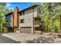 Charming multi-level home featuring an attached garage, a chimney and a cozy second-floor balcony at 4843 Silver Spruce Ln, Evergreen, CO 80439