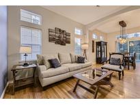 Comfortable living room featuring a plush sofa, stylish decor, and hardwood floors at 3120 Redhaven Way, Highlands Ranch, CO 80126