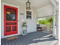 Inviting front porch featuring a vibrant red door and comfortable seating area with stylish decor and ambient lighting at 5801 W 33Rd Ave, Wheat Ridge, CO 80212