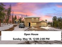Inviting home exterior with an open house sign set against a colorful sky and snowy landscape at 27987 Pine Grove Trl, Conifer, CO 80433