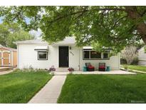 Charming white bungalow with a neatly maintained front yard and inviting porch seating at 1852 S Elm St, Denver, CO 80222