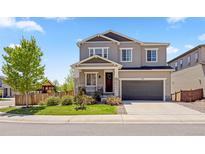 Charming two-story home with a well-maintained lawn, inviting front porch, and attached two-car garage at 1114 Basalt Ridge Loop, Castle Rock, CO 80108
