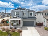 Two-story home featuring gray siding, a two-car garage, a covered porch, and a well-maintained front yard at 1114 Basalt Ridge Loop, Castle Rock, CO 80108