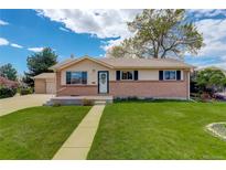 Charming single-story home with brick accents, well-maintained lawn, and inviting walkway to the front door at 11241 Ogden Dr, Northglenn, CO 80233