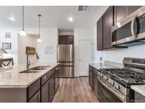 Spacious kitchen with stainless steel appliances, granite countertops, and dark cabinets at 16841 Askins Loop # 101, Parker, CO 80134