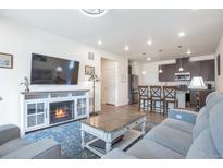 Open-concept living room flows into a kitchen with stainless steel appliances and breakfast bar seating at 16841 Askins Loop # 101, Parker, CO 80134