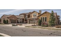 Stunning two-story stucco and stone home with a tile roof and a three-car garage at 9483 Sori Ln, Highlands Ranch, CO 80126