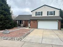 Charming two-story home featuring a brick facade, a two-car garage, and a beautifully landscaped front yard at 7906 W Walker Dr, Littleton, CO 80123