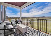 Inviting outdoor patio featuring stylish seating and scenic views of the surrounding landscape under a covered porch at 14998 Cast Pebble Cir, Parker, CO 80134