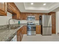 Bright kitchen featuring stainless steel appliances, granite countertops, and ample wood cabinet storage at 13901 E Marina Dr # 113, Aurora, CO 80014