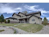 Stately two-story home with a well-manicured lawn, stone accents, and a grand entrance, capturing curb appeal at 14993 W 55Th Dr, Golden, CO 80403