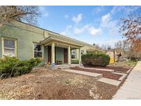 Charming home featuring a covered porch with tasteful landscaping and a well-maintained lawn at 3034 N High St, Denver, CO 80205