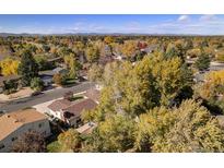 Expansive aerial view of a neighborhood showcasing mature trees and charming homes on a sunny day at 3164 S Nucla St, Aurora, CO 80013