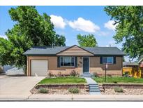 Charming single-story home with brick facade, attached garage, and manicured front yard at 2069 E 116Th Ave, Northglenn, CO 80233