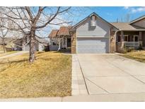 Charming home with a well-maintained lawn, a two-car garage, and beautiful brick accents at 5402 Sweet Grass Ct, Castle Rock, CO 80109