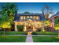 Charming two-story home with a manicured lawn and inviting front porch at twilight at 2324 S Columbine St, Denver, CO 80210