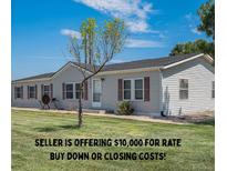Charming single-story home featuring a well-maintained lawn and classic vinyl siding at 8260 County Road 39, Fort Lupton, CO 80621