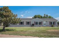 Charming single-story home with a well-maintained lawn and a traditional design in a peaceful suburban setting at 8260 County Road 39, Fort Lupton, CO 80621