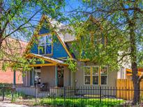 Charming two-story home with a front porch, colorful accents and mature trees at 4348 Umatilla St, Denver, CO 80211