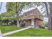 Charming brick townhome featuring a well-manicured lawn and inviting front entrance at 5712 S Lowell Blvd, Littleton, CO 80123