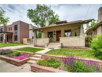 Charming brick home featuring a welcoming front porch and beautifully landscaped yard at 3525 N Alcott St, Denver, CO 80211