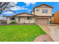 Inviting home featuring a well-maintained lawn, classic brickwork, and a cozy covered porch at 8871 Rutgers St, Westminster, CO 80031