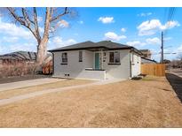 Charming brick home with a well-maintained lawn and a delightful turquoise-colored front door at 3300 Krameria St, Denver, CO 80207