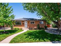 Charming brick home with well-maintained lawn and mature trees offering shade on a sunny day at 3145 W Farmdale Rd, Englewood, CO 80110