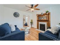 Inviting living room with hardwood floors, fireplace, and comfortable blue seating at 710 E Alameda Ave, Denver, CO 80209