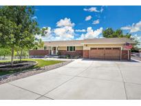 Charming ranch home featuring a well-maintained front yard and an attached two-car garage at 9880 E 157Th Ave, Brighton, CO 80602