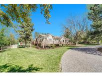 Stunning exterior view of home featuring a wraparound deck, landscaped yard, and a charming gravel driveway at 5255 Ridge Trl, Littleton, CO 80123