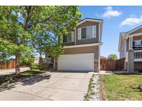 Two-story home featuring a two-car garage and a well-maintained front yard with mature tree at 19560 E 18Th Pl, Aurora, CO 80011