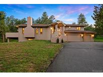 A charming home featuring a spacious driveway, manicured lawn, and an attached two-car garage at 2164 Foothills S Dr, Golden, CO 80401