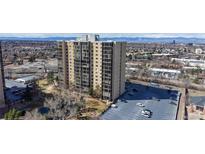 Modern high-rise building with large windows and an adjacent parking lot, set against a backdrop of city and mountains at 7865 E Mississippi Ave # 702, Denver, CO 80247