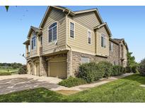 Attractive townhome with beige siding, stone accents, attached garage, and well-maintained landscaping at 371 Granby Way # C, Aurora, CO 80011