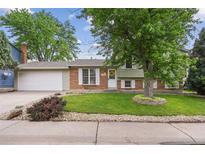 Charming home with well-maintained lawn, mature tree, and brick accents at 9306 Garrison Dr, Broomfield, CO 80021