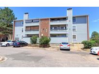 Three-story condo featuring pale-blue siding and brick accents on a sunny day at 14204 E 1St Dr # A12, Aurora, CO 80011