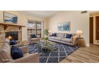 Bright living room features a stone fireplace, plush seating, and sliding door access to outdoor space at 3412 S Eagle St # 202, Aurora, CO 80014