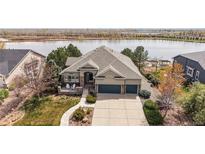 Well-manicured front lawn with large front porch and three car garage at 1738 Edgewater Pl, Longmont, CO 80504